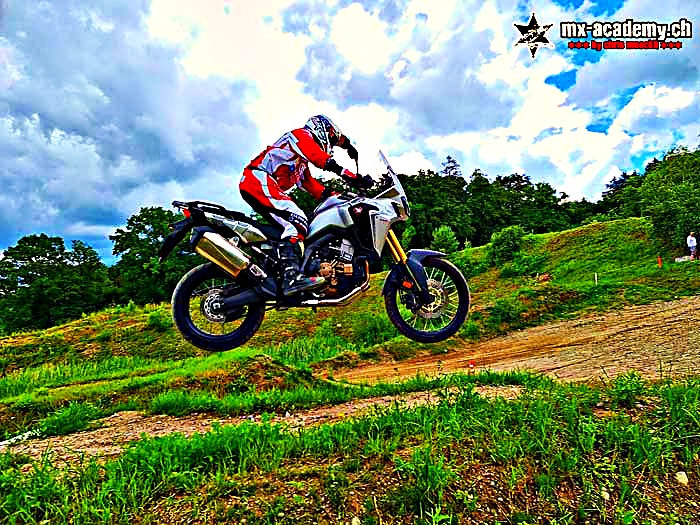 Fahrsicherheitstraining Motorrad mit der Reiseenduro: eine Honda Africa Twin springt über einen Erdhügel