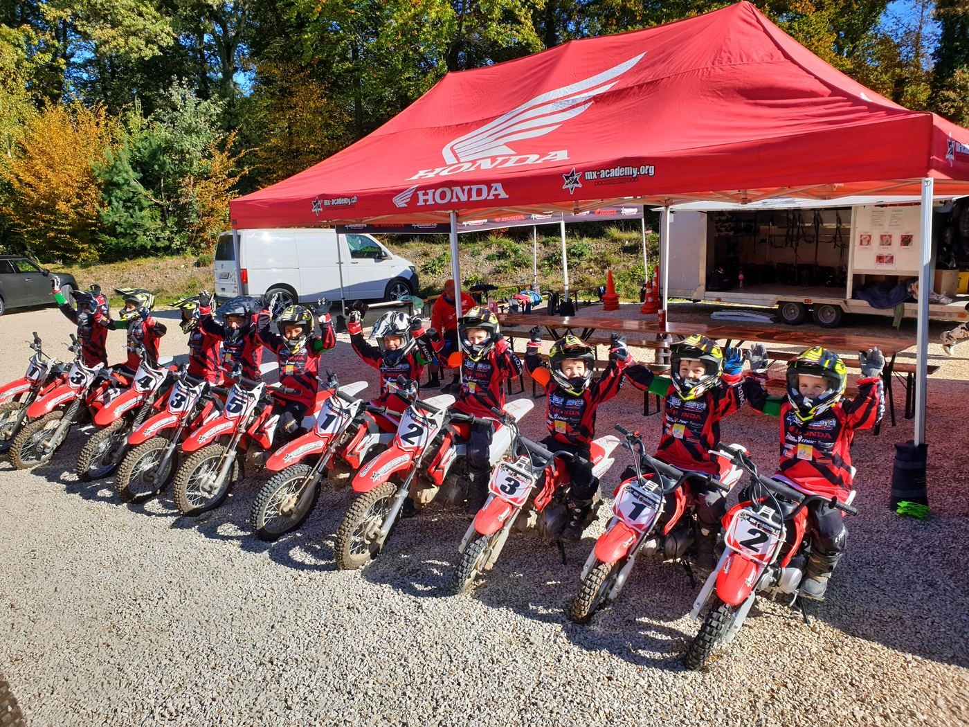 Firmenevent mit Motocross: rotes Honda-Zelt und aufgereihte Motorräder für die Gruppe