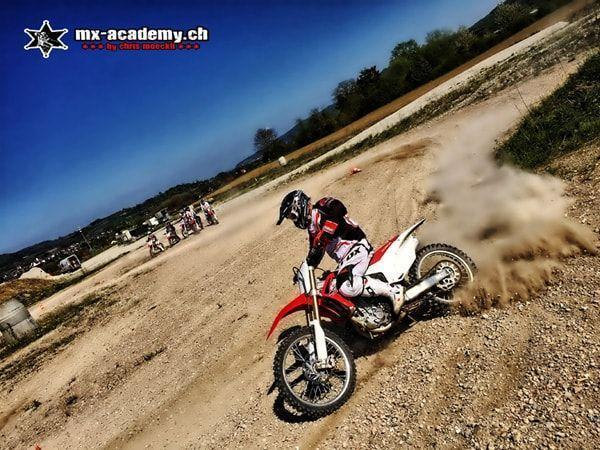 Wochenende mit Motocross: Ein Fahrer wirbelt in der Kurve eine Staubwolke auf, weitere Fahrer warten