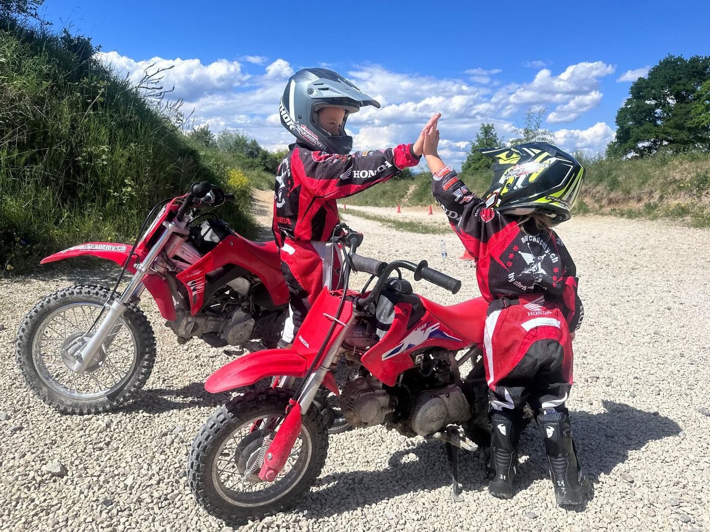 Motocross als Geschenk: zwei Kinder klatschen sich auf ihren Honda-Kinderbikes ab