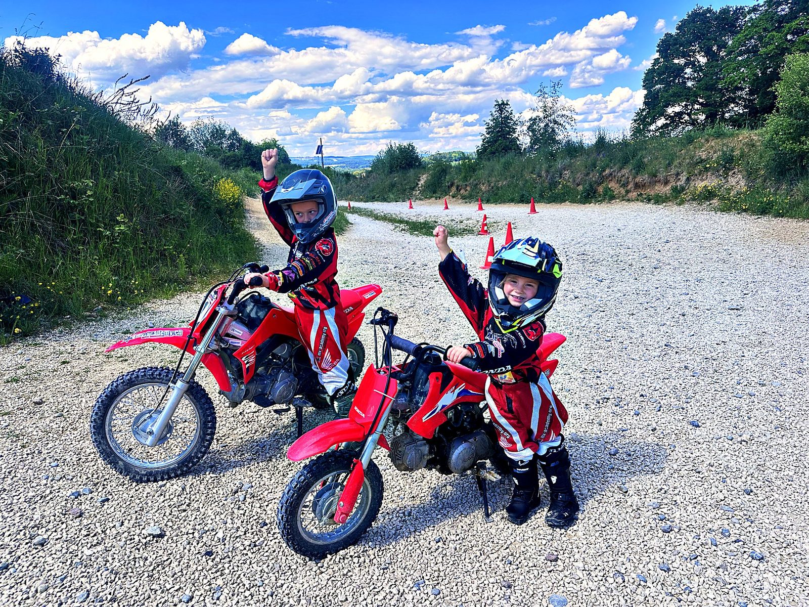 Kinder Motocross für Familien aus Österreich: Kinder auf Honda-Kindermotorrädern am Start, eines hebt den Arm