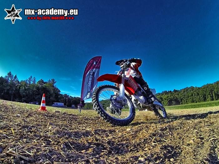 Frauen Motocross: Fahrerin sitzt auf ihrer Honda, in einer Weitwinkelaufnahme fotografiert