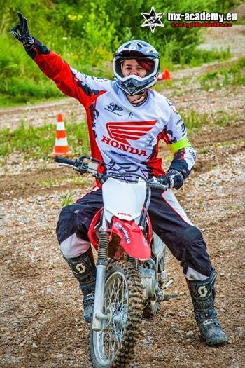 Fahrerin winkt fröhlich von ihrer Honda herüber – Motocross Frauen auf dem Motorrad