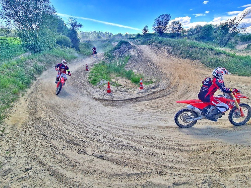 Motocross Kurs ab Österreich: Einsteiger auf roter Honda fährt zwischen Pylonen über die Übungsstrecke