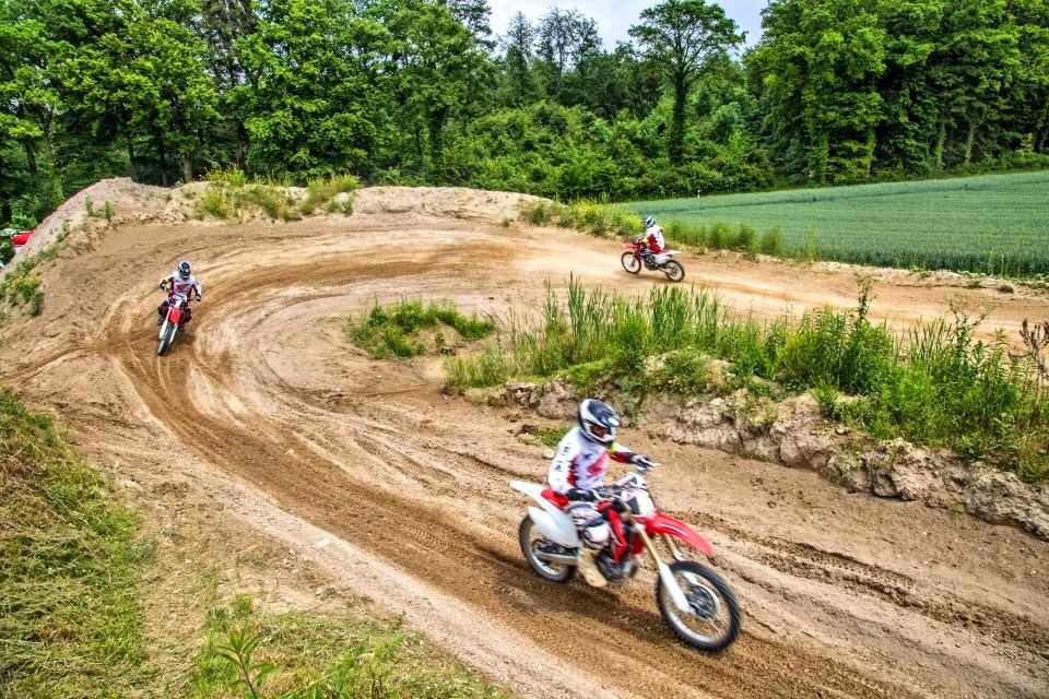 Motocross Strecke mit vielen Kurven: Mehrere Fahrer sind zur gleichen Zeit auf der Piste unterwegs
